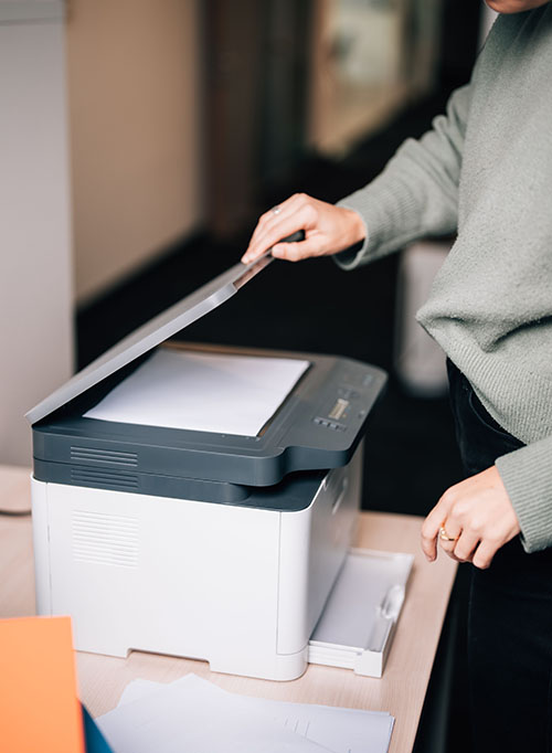 Female office worker using the printer at the office